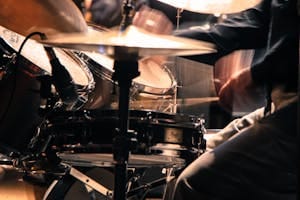 Energetic close-up shot of a drummer playing passionately during a concert performance.
