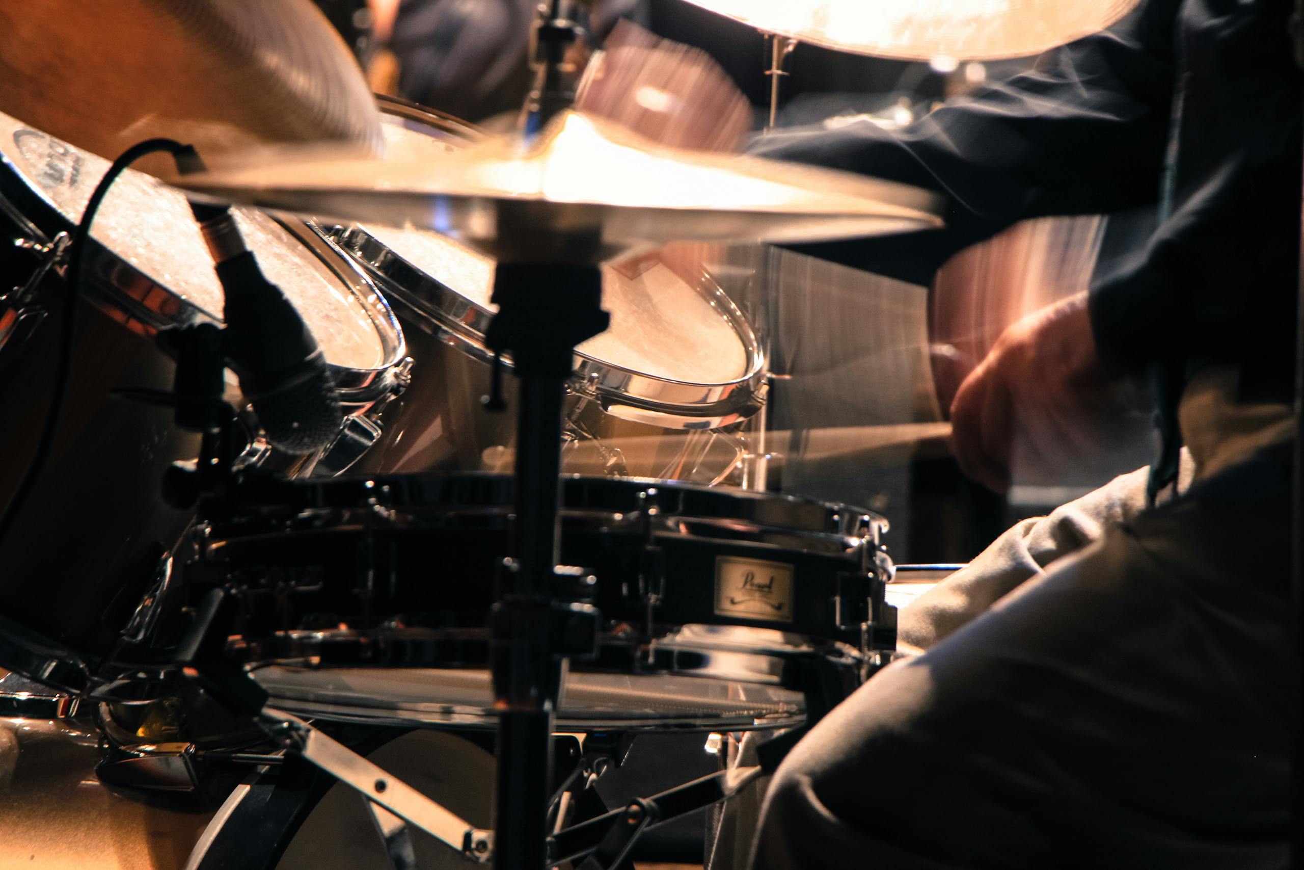 Energetic close-up shot of a drummer playing passionately during a concert performance.